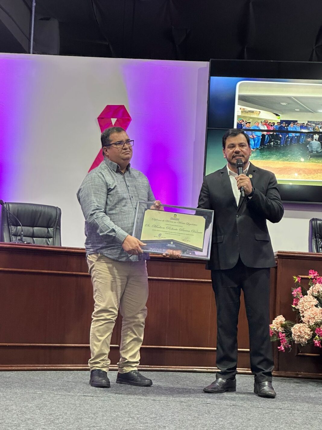 Madson Valente recebe o Diploma de Honra ao Mérito Legislativo das mãos do vereador Marcelo Mourão.
